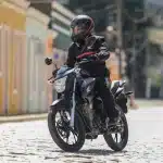 perspectiva-lateral-com-motociclista-pilotando-em-movimento-de-curva-moto-honda-cg-160-titan-cinza-metalico